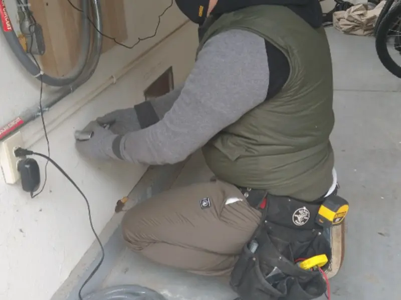 Electrician performing outlet wiring in a Martin garage